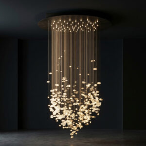 Flagowa, immersyjna lampa kryształowa Gie El – kaskadowa instalacja świetlna z setek delikatnych, świetlistych form zawieszonych na cienkich przewodach, tworząca efekt unoszącej się, świetlnej chmury w eleganckim, ciemnym wnętrzu.